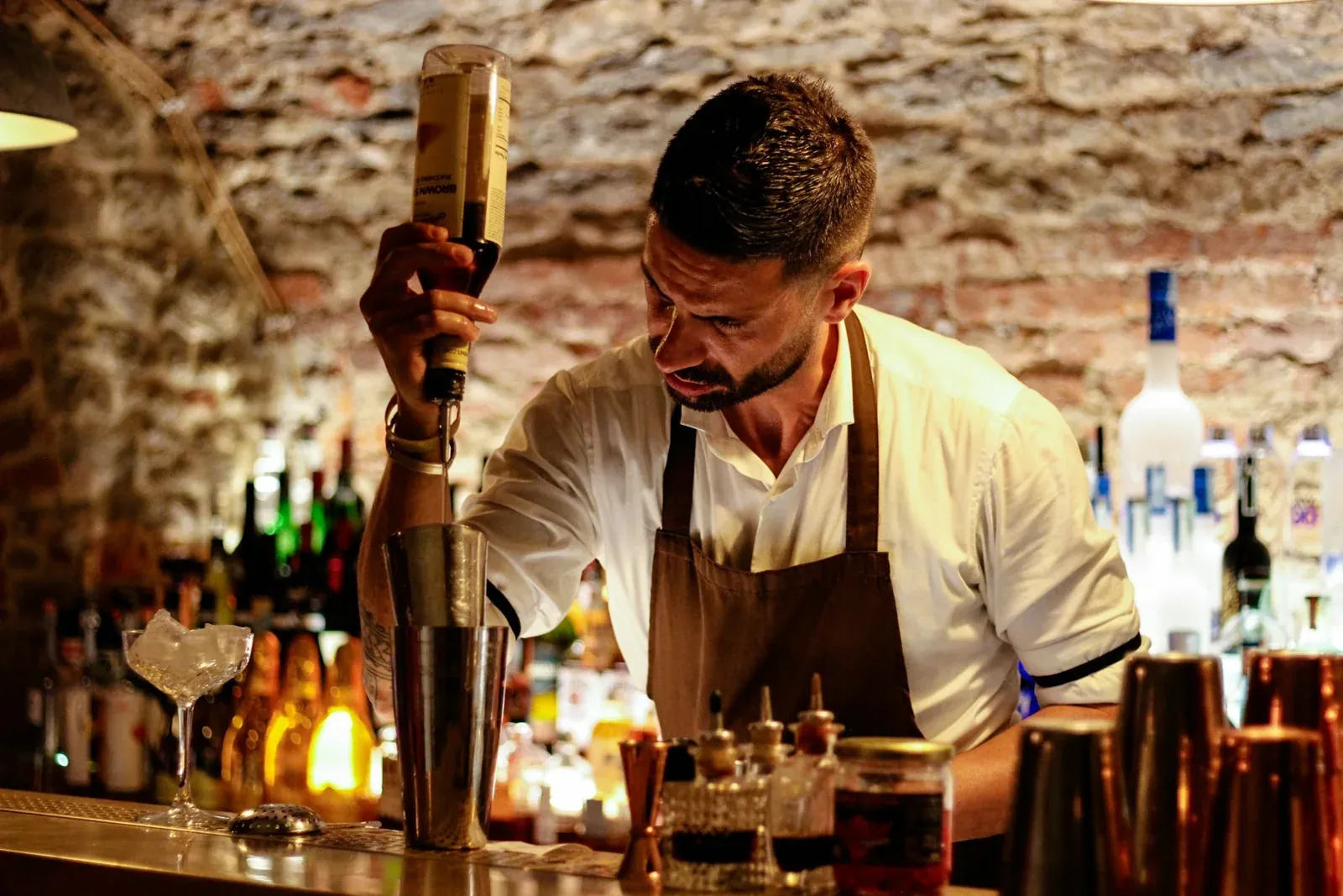 Manos de un bartender preparando un cóctel al momento