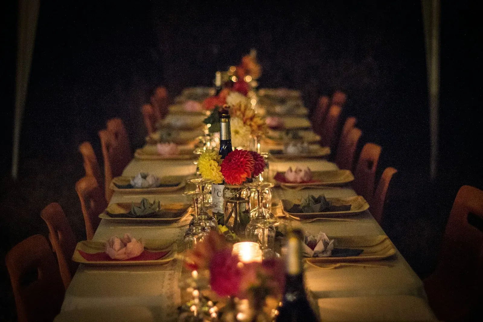 Ambiente de una cena a media luz con mesas y copas